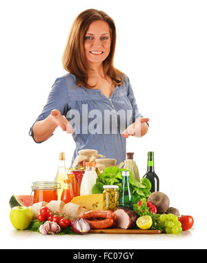 Junge Frau mit unterschiedlichsten Lebensmitteln isoliert auf weiss Stockfoto