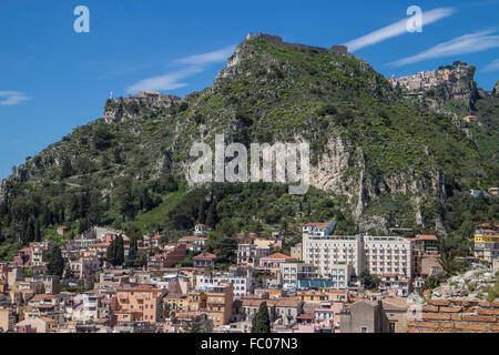 Blick über Taormina, die beliebteste Stadt auf die sizilianische Osten Kosten mit dem kleinen Dorf Castelmola im Hintergrund Stockfoto