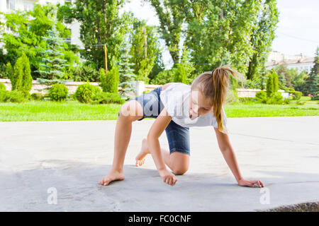 Niedliche Mädchen zieht Kreide auf asphalt Stockfoto