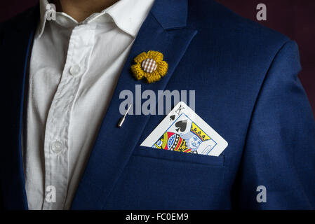 Mann trägt blaue Anzug, Jacke und Blumen Brosche, Pik König Holding in der Tasche, Casino-Konzept Stockfoto