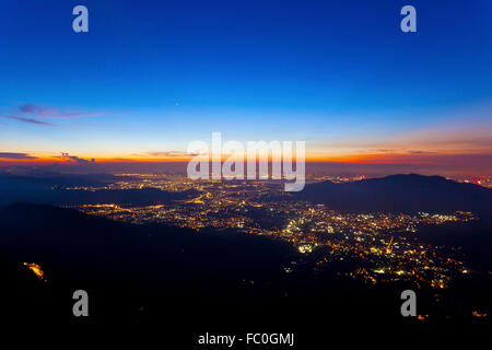 Stadt-Lichter in der Nacht entlang der Berge in Hong Kong Stockfoto