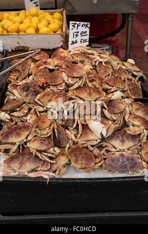 Stapel von Krabben und Zitronen zum Verkauf in einem Meeresfrüchte und Fisch Markt Geschäft in Chinatown, New York City. Stockfoto