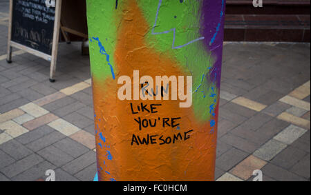 Graffiti auf eine gemalte bunte Lampe post sagen "Run wärst du genial" in Little Italy, New York City Stockfoto