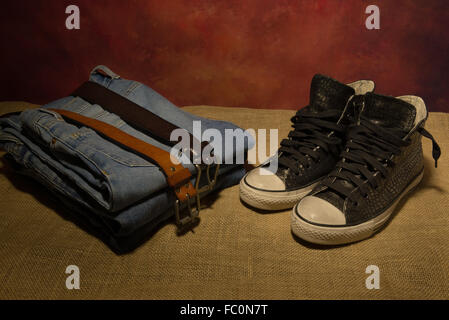 Still-Leben Männer Accessoires, schwarze Schuhe, braune Ledergürtel, Jeans, Stiefel Stockfoto