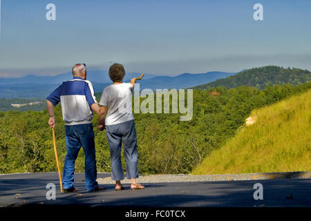 Older couple on a walk looking towards a range of mountains in the Blue Ridge Mountains of North Georgia, USA. Stockfoto