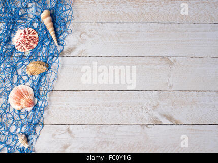 Muscheln und blaues Fischernetz auf Holz Stockfoto