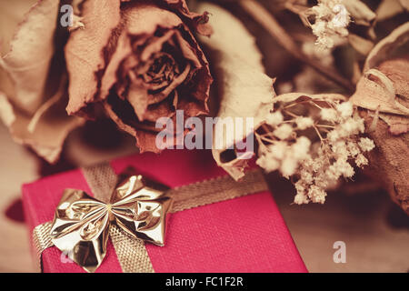 Detail der Bouquet von getrockneten Rosen mit Blättern und roten Geschenkbox, Valentin Konzept. Stockfoto