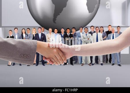 Zusammengesetztes Bild des Handshakes zwischen zwei Frauen Stockfoto