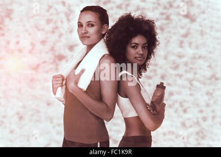 Zusammengesetztes Bild von Fit Frauen stehend mit Wasserflasche und Handtuch Stockfoto