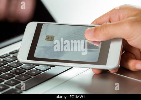 Mann mit Laptop und Handy für Online-shopping Stockfoto