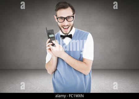 Zusammengesetztes Bild geeky Hipster hält ein Retro-Handy Stockfoto