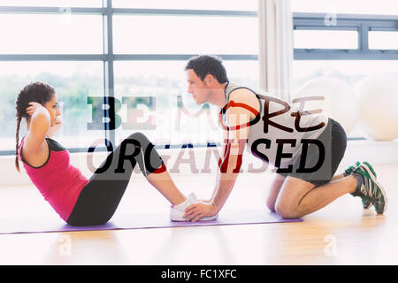 Zusammengesetztes Bild von Trainer helfen Frau Bauch-Crunches im Fitness-Studio zu tun Stockfoto