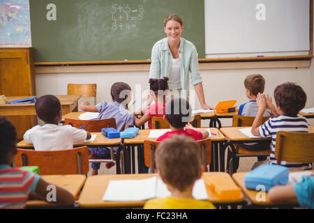 Hübsche Lehrer im Gespräch mit der jungen Schüler im Klassenzimmer Stockfoto