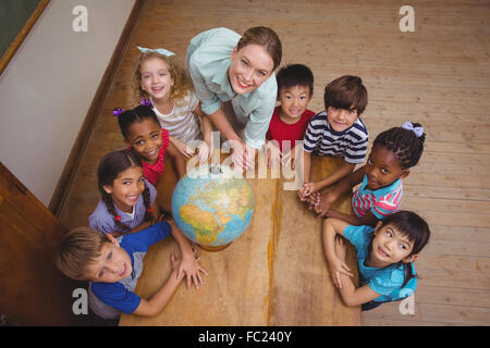 Süß lächelnd weltweit im Klassenzimmer mit Lehrer Schüler Stockfoto