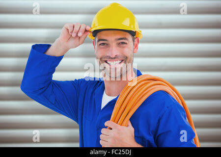 Zusammengesetztes Bild überzeugt Handwerker tragen Schutzhelm Draht Roll mit gedrückter Stockfoto