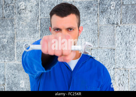 Zusammengesetztes Bild zuversichtlich männlichen Mechaniker Holding Spanner Stockfoto