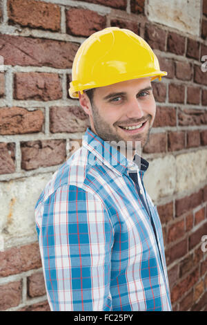 Zusammengesetztes Bild zuversichtlich Mechaniker Schutzhelm tragen Stockfoto