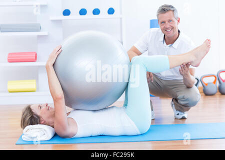 Therapeuten helfen, seine Patienten mit Gymnastikball Stockfoto