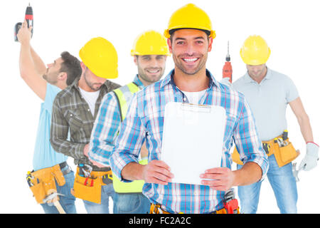 Zusammengesetztes Bild Porträt des Lächelns Arbeiter halten Zwischenablage Stockfoto