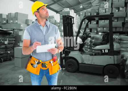 Zusammengesetztes Bild der Arbeiter wegschauen während des Schreibens in Zwischenablage Stockfoto