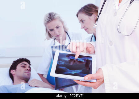 Zusammengesetztes Bild des Arztes betrachten Xray auf tablet Stockfoto