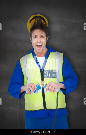 Zusammengesetztes Bild des Elektrikers immer einen Schock Drähte mit gedrückter Stockfoto