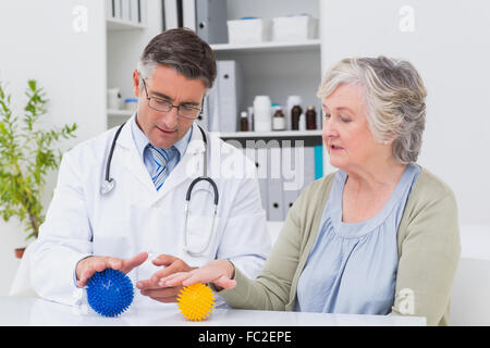 Physiotherapeut guiding Patientin mit Massage-ball Stockfoto