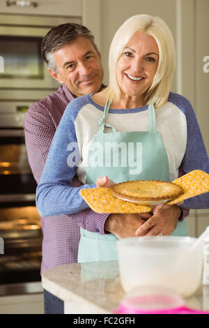 Reife Blondine hält frische Torte mit Mann umarmt Ihr Stockfoto