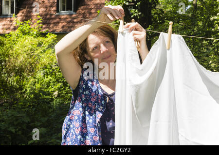 Aufhängen der Wäsche in einem Garten Stockfoto