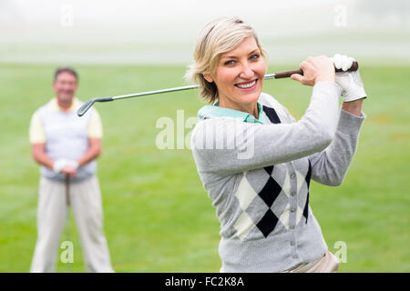 Lady Golfer Abschlag für den Tag beobachtet von partner Stockfoto