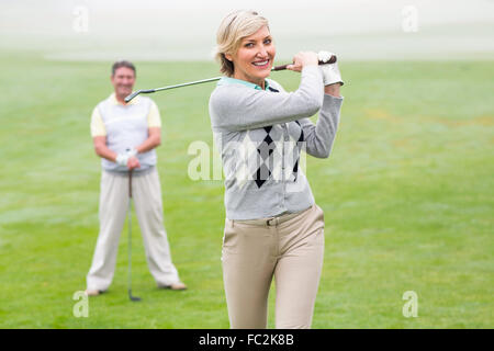 Lady Golfer Abschlag für den Tag beobachtet von partner Stockfoto