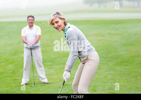 Lady Golfer Abschlag für den Tag beobachtet von partner Stockfoto