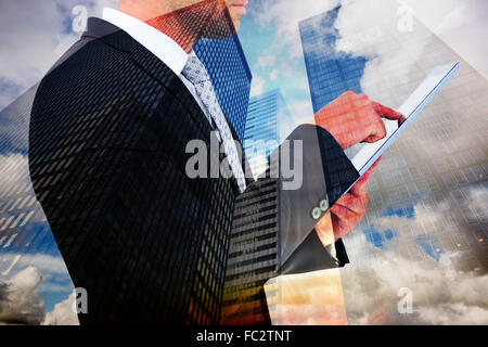 Zusammengesetztes Bild der Geschäftsmann mit seinem TabletPC Stockfoto