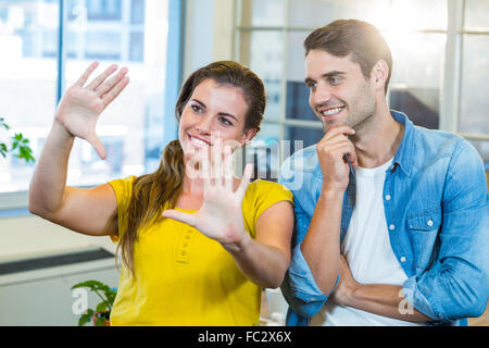Hübsche Geschäftsfrau Rahmen mit ihren Händen zu tun und zu ihrem Partner zeigen Stockfoto