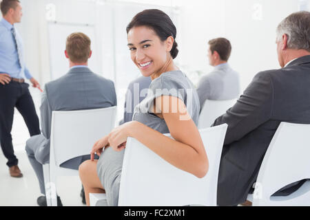 Lächelnde Geschäftsfrau Blick in die Kamera während der Konferenz Stockfoto