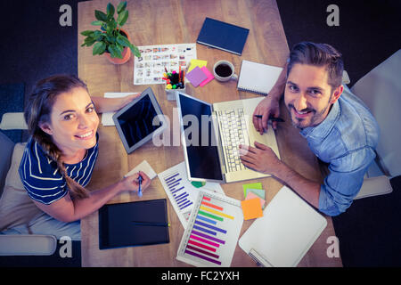 Glückliche kreative Arbeiter teilen Schreibtisch Stockfoto