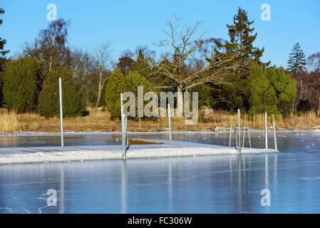 Ein Schwimmen Dock oder Badesteg hat in das Meereis im Winter gefroren. Aus dem Meer mit dem Festland im Hintergrund gesehen. J Stockfoto