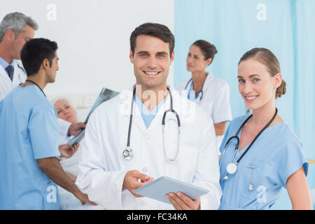 Bericht lesen, mit Kollegen und Patienten hinter Stockfoto