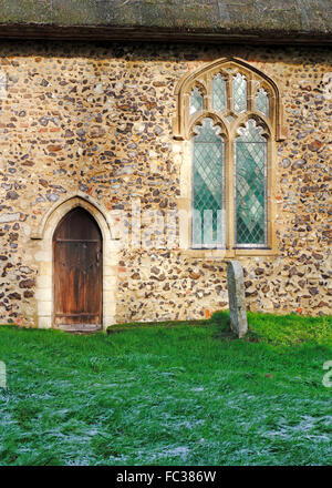 Ein Blick auf des Priesters Tür und Chor-Fenster auf die Pfarrkirche St. Nikolaus bei Potter Heigham, Norfolk, England, UK. Stockfoto