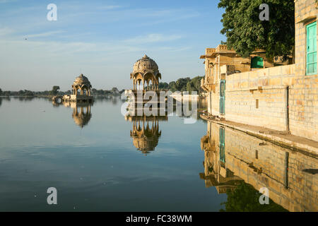 Indische Sehenswürdigkeiten - Gadi Sagar Tempel auf See Gadisar mit Reflexion nach Sonnenaufgang. Der See befindet sich in Jaisalmer, Rajasthan. Stockfoto