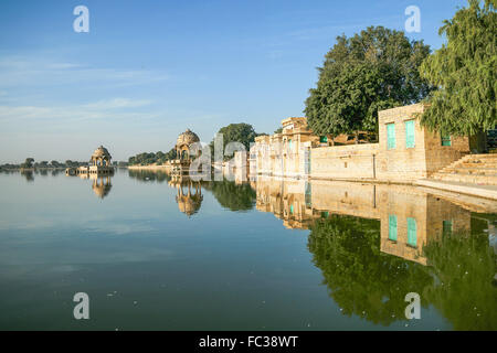 Indische Sehenswürdigkeiten - Gadi Sagar Tempel auf See Gadisar mit Reflexion nach Sonnenaufgang. Der See befindet sich in Jaisalmer, Rajasthan. Stockfoto