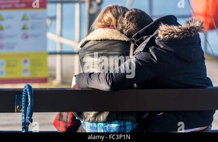 Aberystwyth, West Wales, UK. 20. Januar 2016. Menschen sind unterwegs und genießen den herrlichen Sonnenschein und blauem Himmel, wenn auch kalt.  Ein paar, Mann und Frau teilen einen intimen Moment zusammen am Meer. Bildnachweis: Trebuchet Fotografie / Alamy Live News Stockfoto