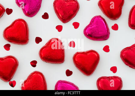 Zum Valentinstag, herzförmige Pralinen und Bonbons auf einem weißen, isolierten Hintergrund. Blick von oben nach unten schaut. Stockfoto