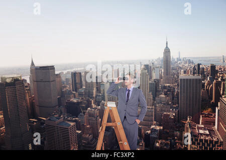 Zusammengesetztes Bild der Unternehmer auf der Suche auf einer Leiter Stockfoto