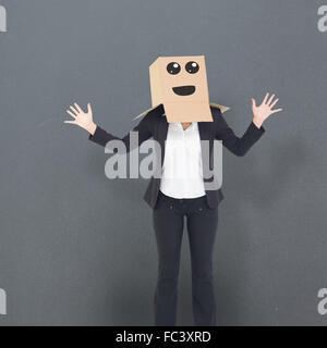 Zusammengesetztes Bild der Geschäftsfrau mit Box über Kopf Stockfoto