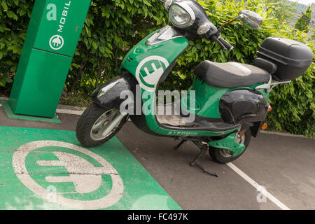 elektrisch angetriebene Moped in der Ladestation Stockfoto