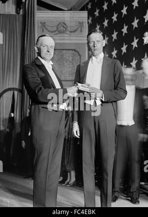 Calvin Coolidge und Charles Lindbergh. Am 11. Juni 1927 präsentiert Präsident Calvin Coolidge Oberst Charles Lindbergh mit der ersten Distinguished Flying Cross-Medaille für seine Solo-Nonstop-Flug über den Atlantik, Stockfoto