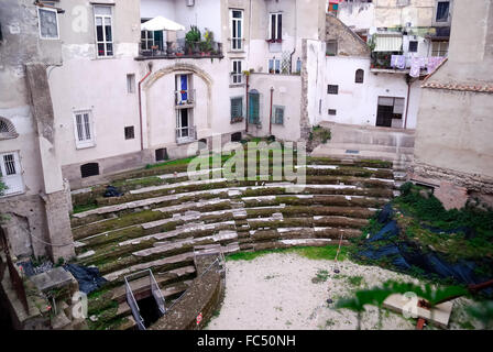 Neapel, Italien. Das römische Theater von Neapolis umgeben von den Häusern, ist eine archäologische Stätte, die im Herzen des historischen Zentrum von Neapel, in der Decumano Maggiore befindet. Die Website befindet sich gerade in dem Bereich zwischen über Altware.  Ein Teil des Theaters ist die letzte Phase der Reise mit der u-Bahn von Neapel, während andere Fragmente entlang der Decumani frei sichtbar sind. Die Häuser wurden auf den Ruinen des antiken römischen Theaters gebaut. Stockfoto