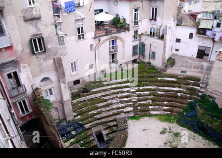 Neapel, Italien. Das römische Theater von Neapolis umgeben von den Häusern, ist eine archäologische Stätte, die im Herzen des historischen Zentrum von Neapel, in der Decumano Maggiore befindet. Die Website befindet sich gerade in dem Bereich zwischen über Altware.  Ein Teil des Theaters ist die letzte Phase der Reise mit der u-Bahn von Neapel, während andere Fragmente entlang der Decumani frei sichtbar sind. Die Häuser wurden auf den Ruinen des antiken römischen Theaters gebaut. Stockfoto