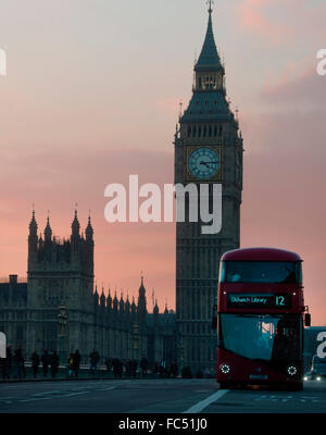 Ein London-Bus fährt über die Westminster Bridge während des Sonnenuntergangs Stockfoto